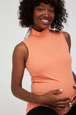 תמונה של גופיית גולף להריון כתומה 