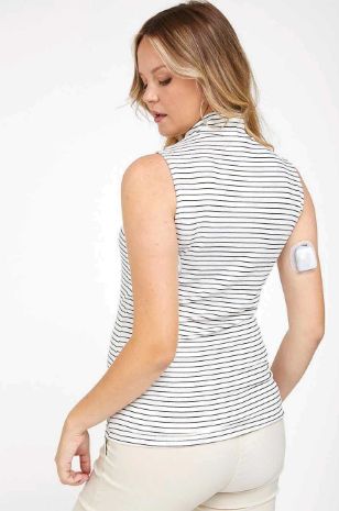 אישה לובשת גופיית גולף להריון שמנת פס שחור של אבישג ארבל	