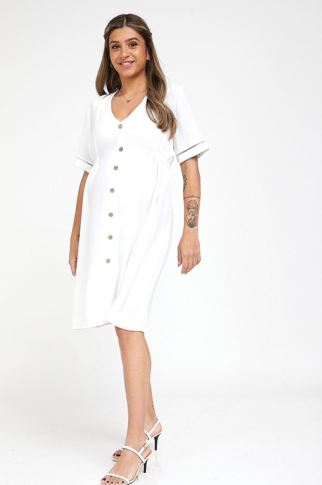 אישה לובשת שמלת הריון בטי לבנה של אבישג ארבל