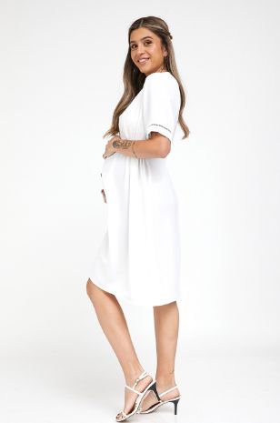 אישה לובשת שמלת הריון בטי לבנה של אבישג ארבל