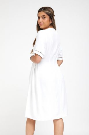 אישה לובשת שמלת הריון בטי לבנה של אבישג ארבל