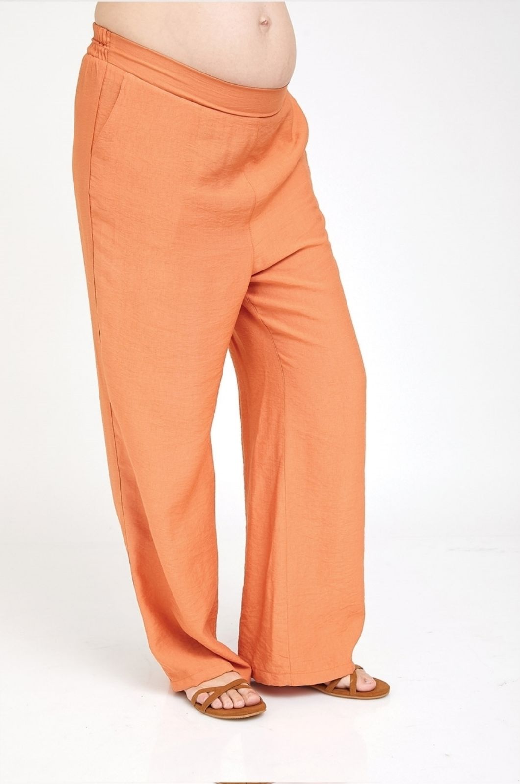 אישה לובשת מכנסי הריון טריסי כתומים