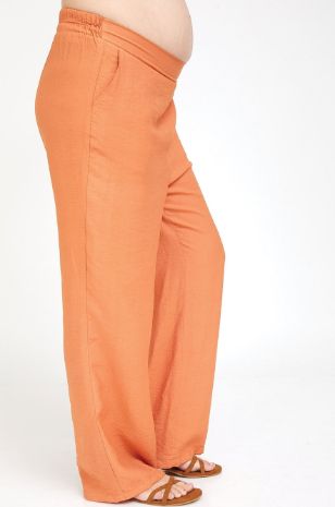 אישה לובשת מכנסי הריון טריסי כתומים