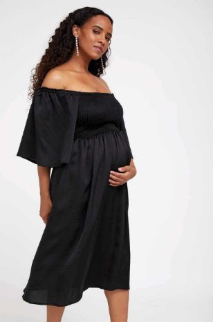 אישה לובשת שמלת הריון פטריס שחורה של אבישג ארבל