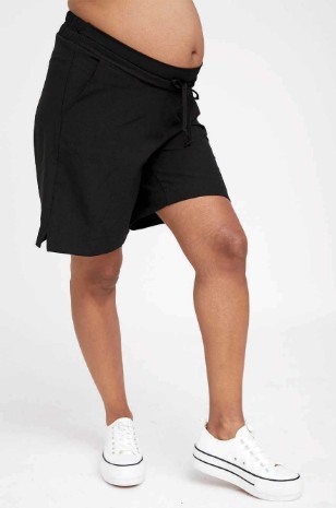 אישה לובשת מכנסי הריון מיקי חול של אבישג ארבל