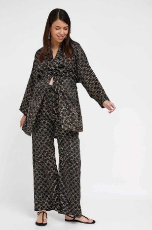 אישה לובשת קימונו סאטן להריון שחור מודפס של אבישג ארבל