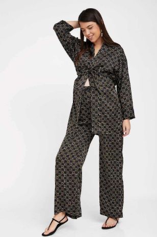 אישה לובשת קימונו סאטן להריון שחור מודפס של אבישג ארבל