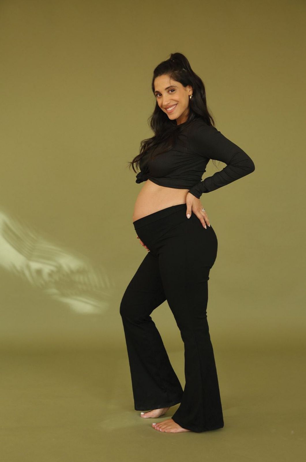 אישה לובשת מכנסי הריון בייסיק מתרחבים ריב שחור