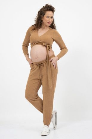 אישה לובשת טופ מעטפת להריון שלי קאמל