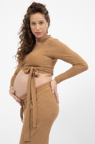 אישה לובשת טופ מעטפת להריון שלי קאמל