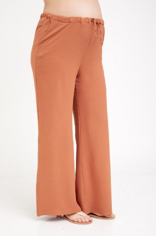 אישה לובשת מכנסי הרפר הריון חמרה - אבישג ארבל