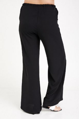 אישה לובשת מכנסי הרפר הריון שחורים