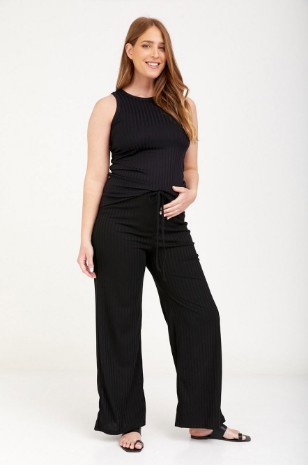 אישה לובשת מכנסי הריון ריבה שחורים