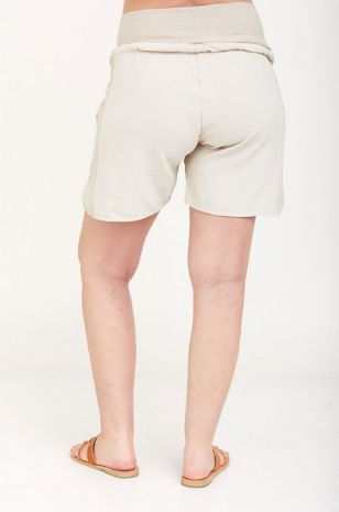 אישה לובשת מכנסי הריון וולרי חול