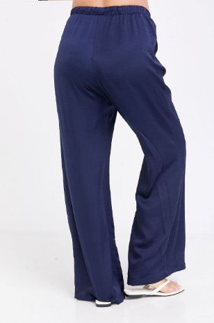 אישה לובשת מכנסי הריון הרפר דמוי סאטן נייבי של אבישג ארבל