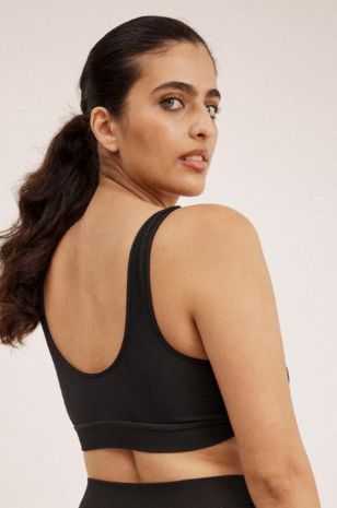 אישה לובשת חזיית הנקה מעטפת ריב Saisei שחורה של אבישג ארבל